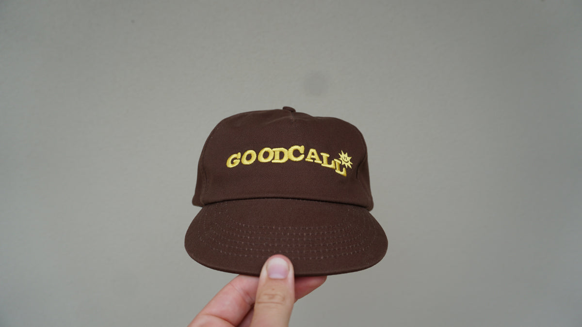 Front view of the brown GOODCALL hat with yellow branding