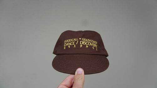 Front view of the brown Discovery hat with yellow lettering and detailing